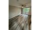 Bright bedroom with large window, ceiling fan, and wood-style flooring at 3349 Overland Dr, Holiday, FL 34691
