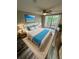Bedroom featuring a large window, ceiling fan, and comfortable bed with a serene beach themed art piece at 3349 Overland Dr, Holiday, FL 34691