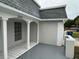 Covered front porch entryway with gray tiled floor and white archways at 3349 Overland Dr, Holiday, FL 34691