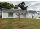 Charming single-Gathering home with a gray tiled roof, white exterior, and attached garage at 3349 Overland Dr, Holiday, FL 34691