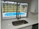 Kitchen sink and faucet with view of pool through window in updated kitchen at 3349 Overland Dr, Holiday, FL 34691