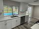 Kitchen with white cabinets, quartz countertops, and a view of the backyard pool at 3349 Overland Dr, Holiday, FL 34691