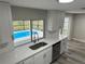 Modern kitchen with white cabinets, quartz countertops, and stainless steel appliances overlooking a pool at 3349 Overland Dr, Holiday, FL 34691