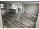 Open-concept living area and kitchen with gray wood-look flooring at 3349 Overland Dr, Holiday, FL 34691