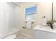 Clean bathroom with white tiles, modern fixtures, and vanity with quartz countertop at 341 Bahia Vista Dr, Indian Rocks Beach, FL 33785