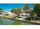 Exterior view of the property from the waterfront, showcasing palm trees and a patio at 341 Bahia Vista Dr, Indian Rocks Beach, FL 33785