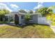Side view of a house with a white fence, landscaping, and a wooden accent wall at 341 Bahia Vista Dr, Indian Rocks Beach, FL 33785