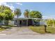 Front view of a single-story home with a driveway, landscaping, and palm trees at 341 Bahia Vista Dr, Indian Rocks Beach, FL 33785