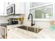 Modern kitchen with stainless steel appliances, white cabinets, and marble countertops at 341 Bahia Vista Dr, Indian Rocks Beach, FL 33785