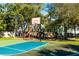 Playground with basketball court, slides, and swings surrounded by trees at 341 Bahia Vista Dr, Indian Rocks Beach, FL 33785