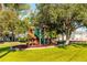 Community playground with slides, swings, and a large tree for shade at 341 Bahia Vista Dr, Indian Rocks Beach, FL 33785