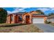 Single-story home with stucco exterior, arched entryway, and attached garage at 4401 Plumosa St, Spring Hill, FL 34607
