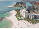 Stunning coastal view with a white sandy beach, clear water, and resort buildings at 504 79Th Ave, St Pete Beach, FL 33706