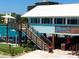 Exterior view of a waterfront restaurant with outdoor seating and stairs leading to the entrance at 504 79Th Ave, St Pete Beach, FL 33706