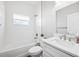 Bright bathroom features a tub with shower, a white vanity, and a modern faucet at 6454 Freeport Dr, Spring Hill, FL 34608