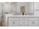 Spa-like bathroom with dual sinks, a large mirror, and a glass-enclosed shower featuring elegant tile work at 6454 Freeport Dr, Spring Hill, FL 34608