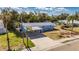 Aerial view of a blue home with a carport, driveway, and palm trees at 660 Flamingo Dr, Apollo Beach, FL 33572