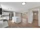 Open kitchen with white cabinets, stainless steel appliances, and a large island overlooking the living area at 660 Flamingo Dr, Apollo Beach, FL 33572