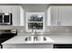 Close-up of the kitchen sink with stainless steel faucet and white quartz countertops at 660 Flamingo Dr, Apollo Beach, FL 33572