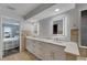 Double vanity sinks, white cabinets, tile floor, and a view to the bedroom at 6613 Seabird Way, Apollo Beach, FL 33572