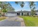Single-story home with a paved driveway and attached garage at 6613 Seabird Way, Apollo Beach, FL 33572