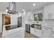 Modern kitchen with white cabinets, stainless steel appliances, and an island with a sleek cooktop at 6613 Seabird Way, Apollo Beach, FL 33572