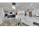 Open-concept kitchen and living room with white cabinets, a glass-top dining table, and a view of the living area at 6613 Seabird Way, Apollo Beach, FL 33572