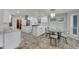 Modern white kitchen with quartz countertops, stainless steel appliances, and a breakfast nook area at 6613 Seabird Way, Apollo Beach, FL 33572