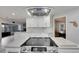 Close-up of the kitchen island with a smooth cooktop, white cabinets, and a view into the living area at 6613 Seabird Way, Apollo Beach, FL 33572