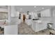 Spacious white kitchen with an island, stainless steel appliances, and quartz countertops at 6613 Seabird Way, Apollo Beach, FL 33572