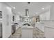 White kitchen featuring an island, stainless steel appliances, and ample counter space at 6613 Seabird Way, Apollo Beach, FL 33572