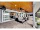 Covered patio with ceiling fans, outdoor kitchen, and sliding glass doors to the living room at 6613 Seabird Way, Apollo Beach, FL 33572