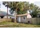 Small, tan detached building in a fenced backyard with a palm tree at 8303 N Mulberry St, Tampa, FL 33604