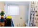 Bathroom with a toilet, shower, and window with blinds at 8303 N Mulberry St, Tampa, FL 33604