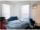 Bedroom with two windows, blinds, a bed, and a fan at 8303 N Mulberry St, Tampa, FL 33604
