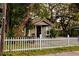 Charming home with a white picket fence and lush landscaping at 8303 N Mulberry St, Tampa, FL 33604