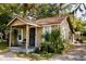 Welcoming home with front porch, mature landscaping, and a fenced yard at 8303 N Mulberry St, Tampa, FL 33604