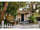 Quaint home with white picket fence, front porch, and mature trees at 8303 N Mulberry St, Tampa, FL 33604