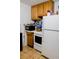 Kitchen features wood cabinets, white appliances, and tile flooring at 8303 N Mulberry St, Tampa, FL 33604