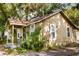 Side view of the single-story home with porch and landscaping at 8303 N Mulberry St, Tampa, FL 33604
