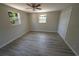 Bedroom with wood-look flooring, neutral walls, a ceiling fan, and white closet doors at 8391 76Th Ave, Seminole, FL 33777