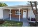 Covered front porch with decorative columns and a charming front door at 8391 76Th Ave, Seminole, FL 33777