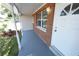 Covered porch entryway with brick exterior and white door at 8391 76Th Ave, Seminole, FL 33777