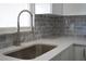 Modern kitchen features stainless steel faucet, gray tile backsplash, and white countertops at 8391 76Th Ave, Seminole, FL 33777