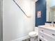 Modern bathroom with a white vanity, blue accent wall, and unique hexagonal floor tiles at 912 Channelside Dr # 2412, Tampa, FL 33602