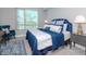 Cozy bedroom with blue bedding, matching area rug, and a small desk and chair in the corner at 912 Channelside Dr # 2412, Tampa, FL 33602