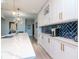 Bright kitchen showcasing white shaker cabinets, marble countertops, gold fixtures, and a blue tile backsplash at 912 Channelside Dr # 2412, Tampa, FL 33602