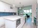 Modern white kitchen with gold hardware, marble countertops, and blue tile backsplash at 912 Channelside Dr # 2412, Tampa, FL 33602