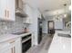Modern white kitchen with gold hardware, stainless steel appliances, and a decorative tile backsplash at 912 Channelside Dr # 2412, Tampa, FL 33602