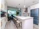 Modern white kitchen with an island, bar seating, gold accents, and blue tile at 912 Channelside Dr # 2412, Tampa, FL 33602